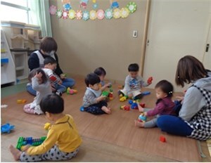 室内でブロック遊びをする子供たちと先生