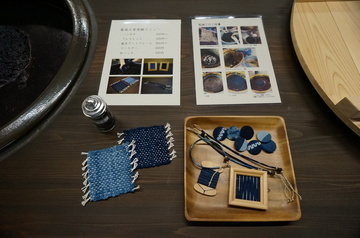 藍で染められた糸や布を使って作られたボタンなどの小物の写真