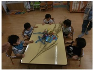 机の周りで笹飾りを囲む子供たちの様子
