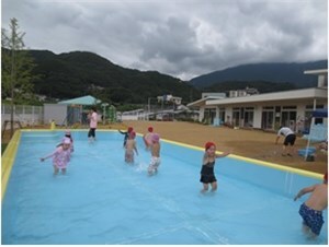 プールで水をかけ合ったりしながら遊ぶ子供達の様子