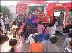 消防士が子どもたちに消防車の仕組みを説明する画像