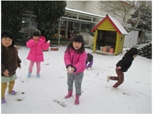 雪が積もった園庭で遊ぶ園児たちの様子