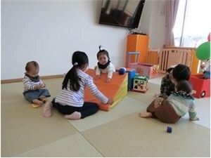 5歳児のお姉ちゃん達が0歳児のお友達と遊ぶ様子の画像