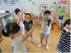 教室で両手を挙げてダンスする園児たちの様子