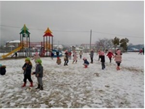 雪の積もった園庭で遊ぶ子供たち